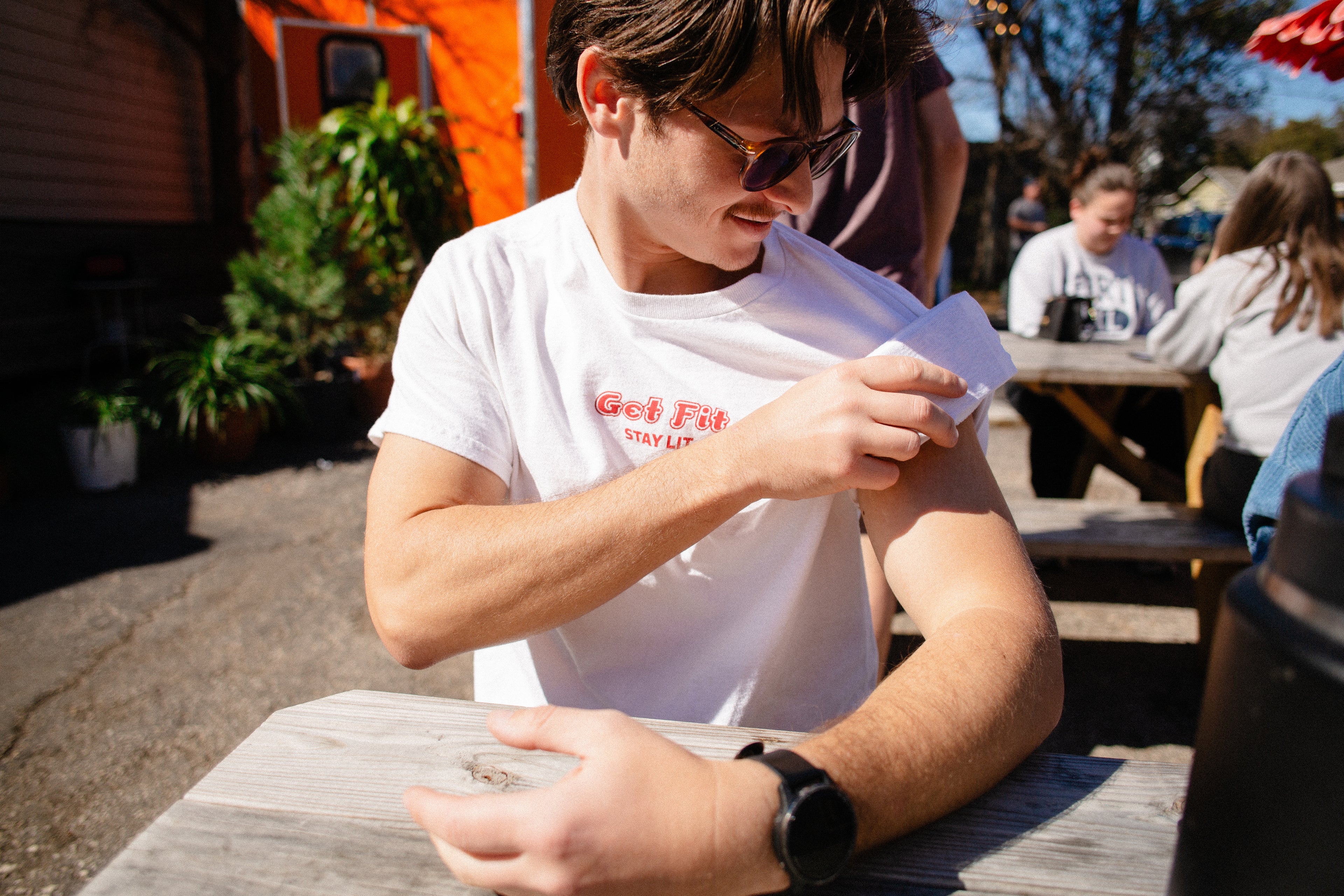 pesonal training coach rolling Yudae's Training Card game in the Get Fit Stay Lit t-shirt